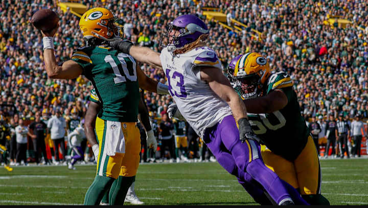 Jordan Love, the quarterback for the Green Bay Packers, throws the ball away when the Vikings